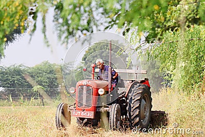 An Indian senior man farmer plowing the field with a tractor plow Editorial Stock Photo